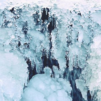 Frozen stream. Beautiful winter nature background. Frost, ice and snow in the winter.