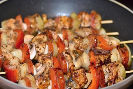 Chicken skewer with vegetables. Frying in a pan.