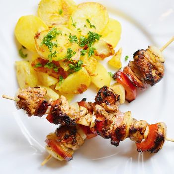 Chicken skewer with potatoes and parsley. Excellent meat with vegetables.