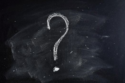 Question mark drawn in chalk on a blackboard.