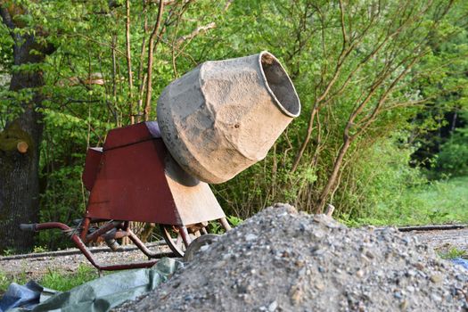 Concrete mixer at sunset. Natural green background.