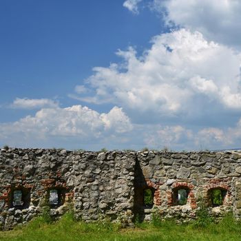 The walls of the castle with a background of blue sky and clouds.