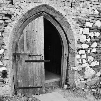 Old open the church door with a brick wall.