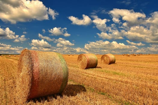 Beautiful countryside landscape. Hay bales in harvested fields. 