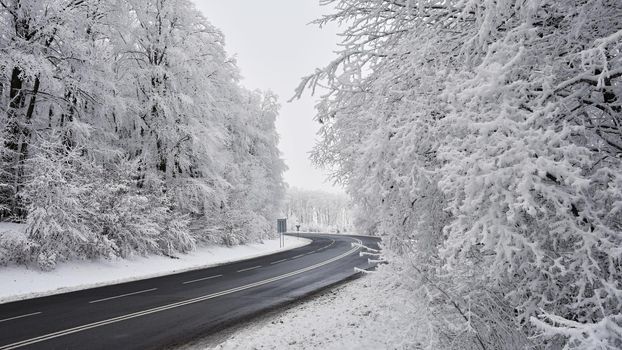 Empty road with snow covered landscape. Beautiful winter seasonal background for transport and cars.
