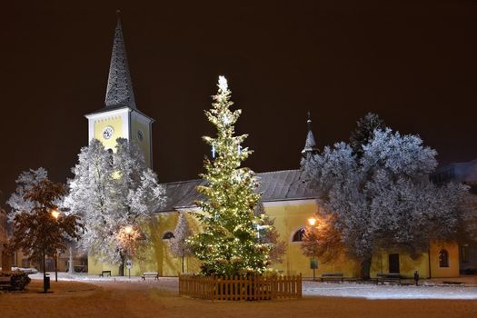 Beautiful night winter photo Christmas tree with church and snow.