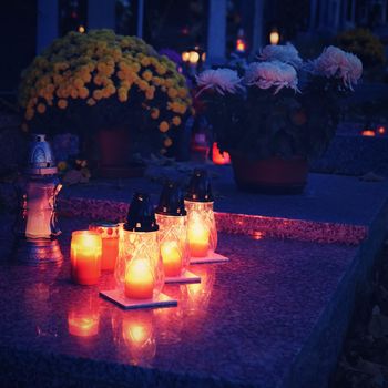 Beautiful autumn concept. Cemetery and Halloween. Candle in a lantern on the grave. Background for Halloween.