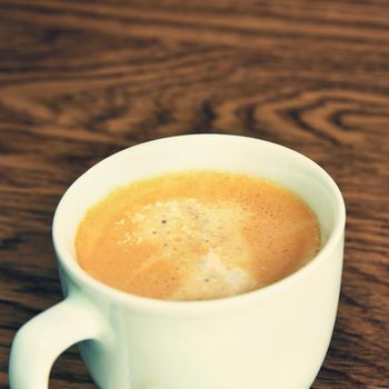 Coffee Espresso. White small cup of coffee on the wooden background.