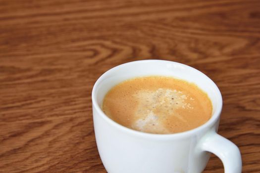 Coffee Espresso. White small cup of coffee on the wooden background.