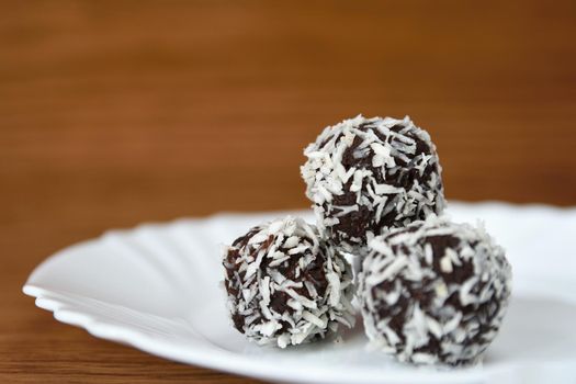 Christmas sweets on a plate - Rum balls in coconut. Traditional homemade handmade Czech sweets.