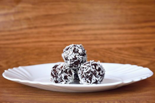 Christmas sweets on a plate - Rum balls in coconut. Traditional homemade handmade Czech sweets.