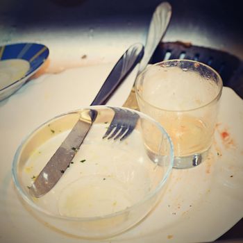 Dirty dishes in a stainless steel sink in the kitchen.