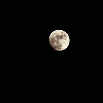 Full moon over dark black sky at night