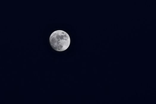 Full moon over dark black sky at night