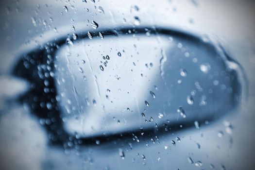 Winter car, the concept of winter car ride. Mirror and ice and water drops on the windscreen.