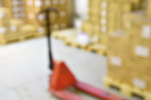 Blurred background warehouse. Abstract blurry warehouse storing. The interior of the warehouse with boxes and pallets.