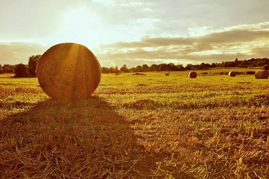 Beautiful countryside landscape. Hay bales in harvested fields. 