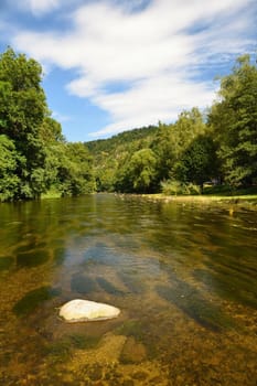 Beautiful summer landscape with river, forest, sun and blue skies. Natural background. Green.