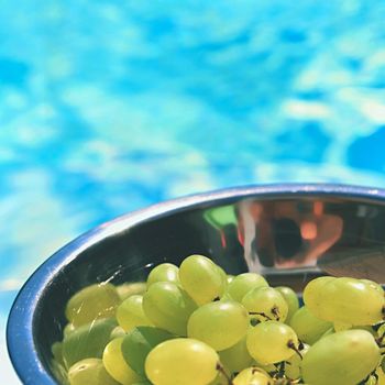 grapes in a bowl with a background of blue water