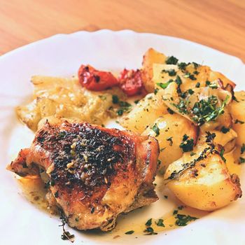 Roast chicken with potatoes and vegetables.