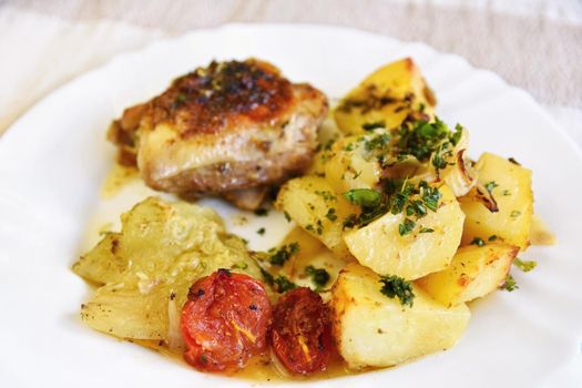 Roast chicken with potatoes and vegetables.