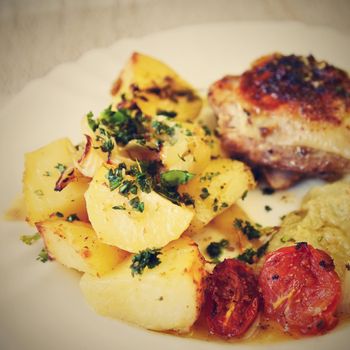 Roast chicken with potatoes and vegetables.