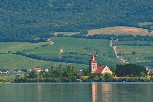 The island with the old church in the middle of the lake. Landscape under Palava. Czech Republic - South Moravian Region wine region. Water tank - New Mills - Pasohlavky.