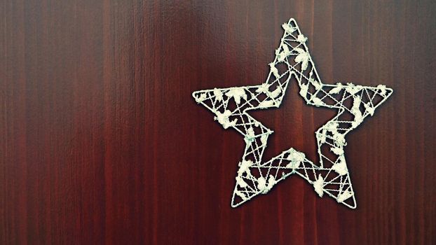 Christmas star ornament on a wooden background. Beautiful concept for Christmas time and winter.