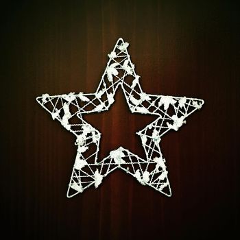 Christmas star ornament on a wooden background. Beautiful concept for Christmas time and winter.