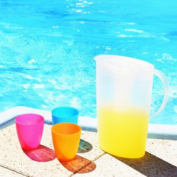 Drinks with cups and kettle. Background with water on a hot sunny day. Summer holiday idyllic