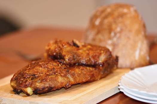 Roasted pork ribs. On wooden background bread.