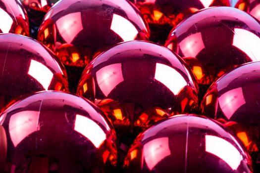 full frame background of red mirror balls close-up with selective focus and blur
