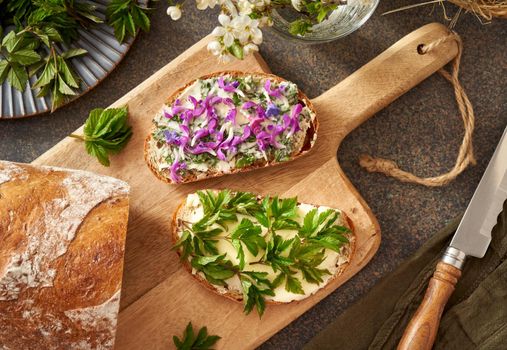 Sourdough bread with butter and young goutweed leaves collected in spring, purple dead-nettle and lungwort flowers