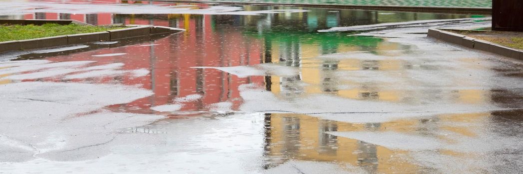 Puddle reflection of vintage apartment house in a rainy day.