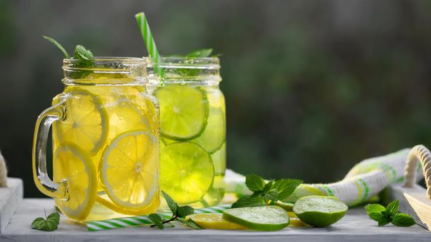 Cold refreshing homemade lemonade with mint, lemon and lime in mason jars.