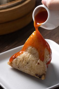 Eating Zongzi rice dumpling for Chinese traditional Dragon Boat Festival (Duanwu Festival) celebration event concept.