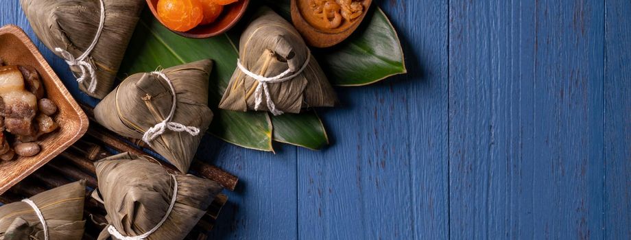 Zongzi rice dumpling with ingredients top view for Chinese traditional Dragon Boat Festival (Duanwu Festival) over blue wooden table background.