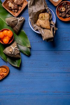 Zongzi rice dumpling with ingredients top view for Chinese traditional Dragon Boat Festival (Duanwu Festival) over blue wooden table background.