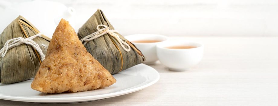 Zongzi. Rice dumpling for Chinese traditional Dragon Boat Festival (Duanwu Festival)  on bright wooden table background.