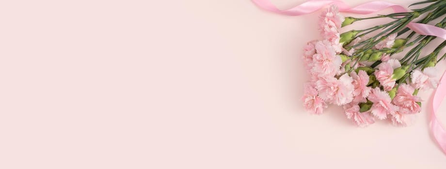 Design concept of Mother's day holiday greeting design with carnation bouquet on pastel pink table background