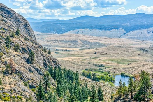 Beautiful overview of Okanagan valley with small lake downhill on a bright sunny day