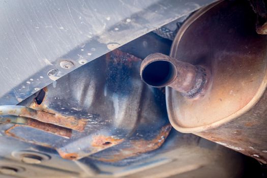 Close up of old and rusty exhaust pipe of a car