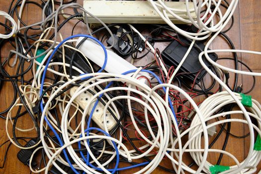A tangled tangle of unnecessary wires lies on the floor.