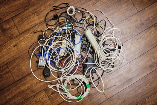A tangled tangle of unnecessary wires lies on the floor.