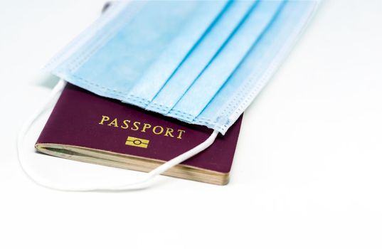 Surgical face mask over a passport. Traveling during the Covid 19 coronavirus pandemic. Virus protection and prevention measures. Travel restrictions