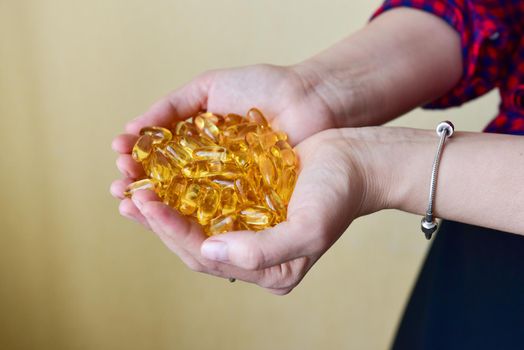 Hands holding fish oil Omega-3 capsules. Medical healthcare, healthy nutrition supplements concept. Vitamin tablets.