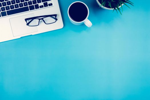 Flat lay, Laptop computer and plant and cup of coffee and glasses on desk in office, workplace and notebook and potted tree, workspace and copy space, top view, object with above, business concept.