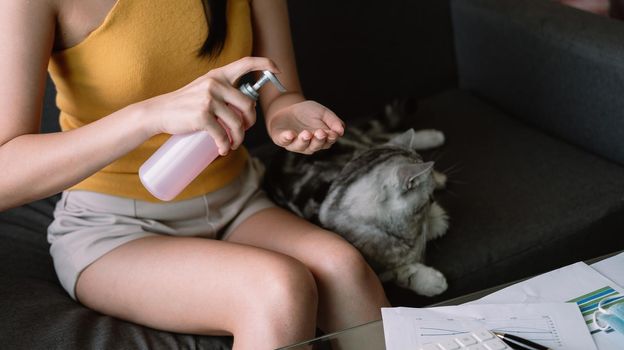 Woman work from home, Washing your hand by alcohol sanitizer gel for protecting infection from a Covid-19 virus and other viruses.