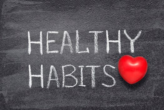 healthy habits phrase written on chalkboard with red heart symbol
