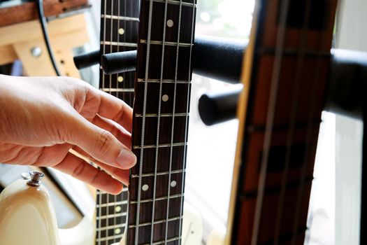 close up Image of Hand picking up guitar